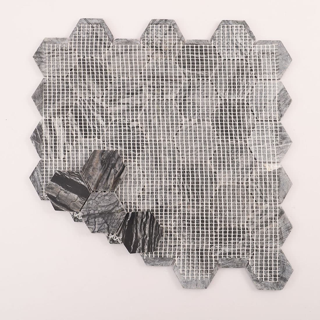 Back view of mesh-backed marble hexagon mosaic sheet with a small tile cluster.