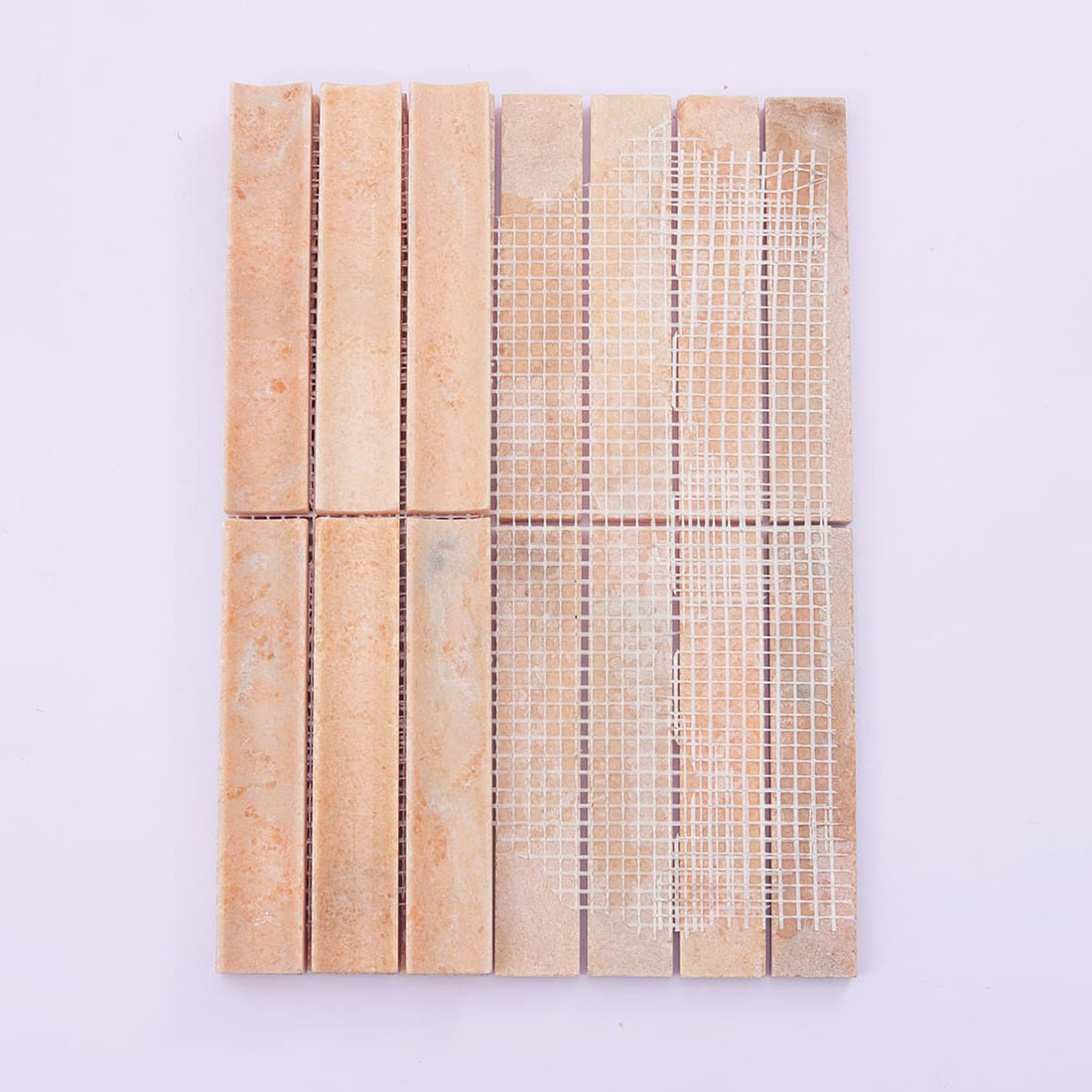 Back view of mesh-mounted peach grooved stone strip mosaic tile sheet