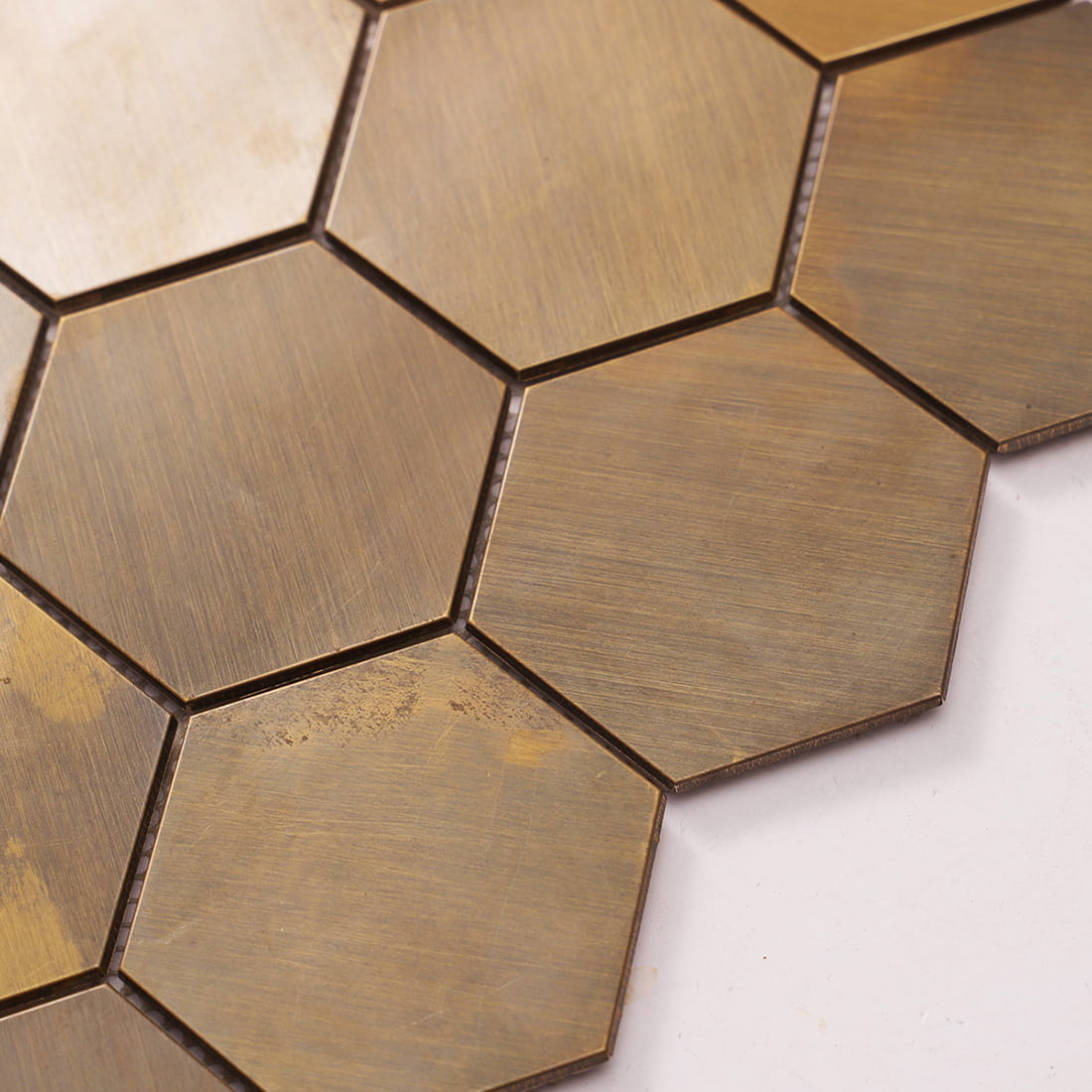 Detail of metallic bronze hexagon tiles showing the mesh backing in between.