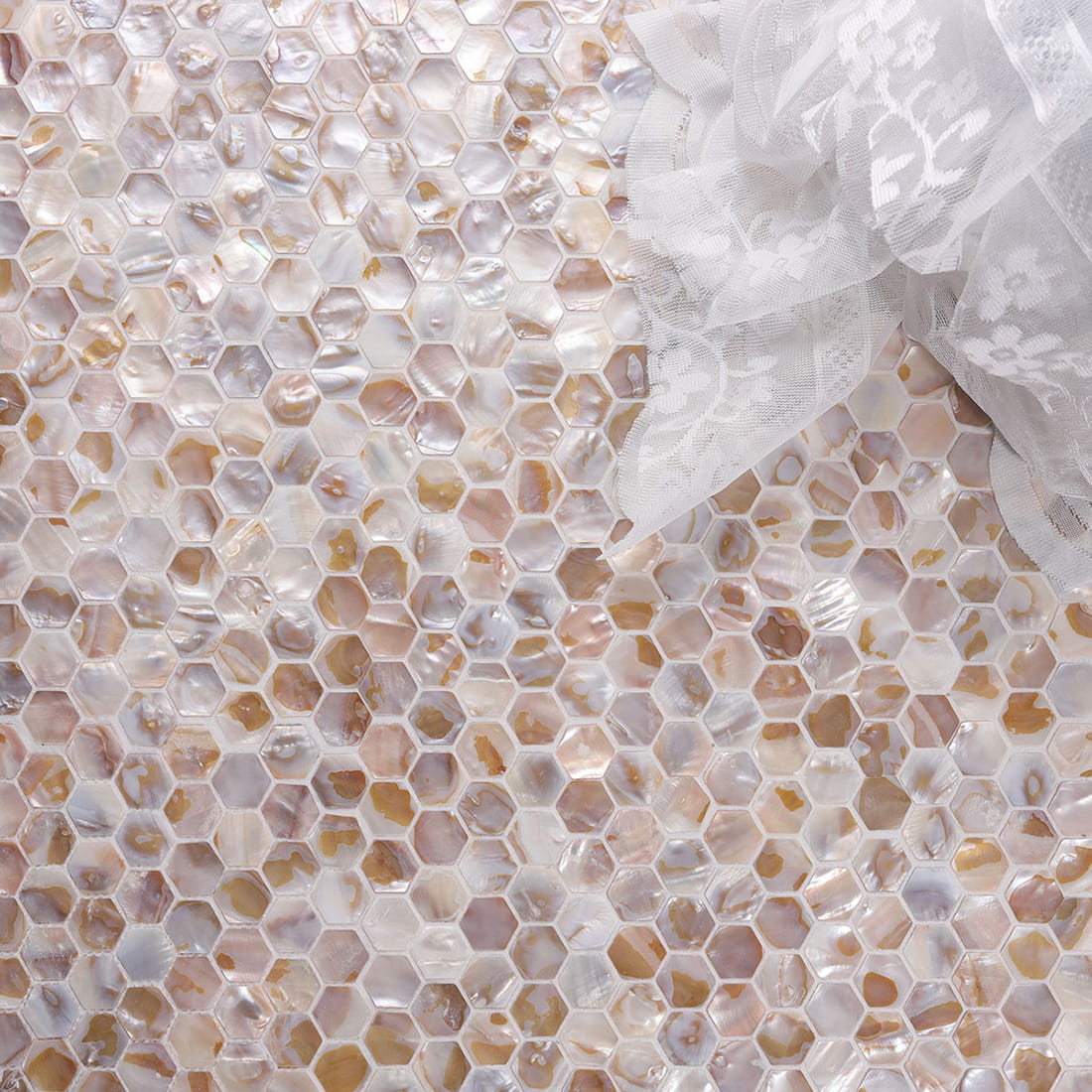 Lifestyle flat lay of beige mother of pearl mini hexagon mosaic tile surface
