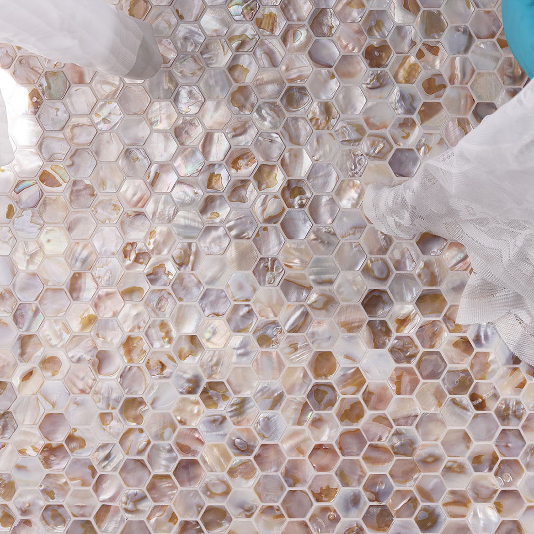 Beige mother of pearl mini hexagon mosaic tile styled with sheer fabric