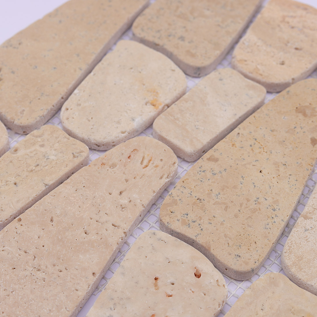 Close-up of beige pebble stone mosaic with natural pores and tonal variation