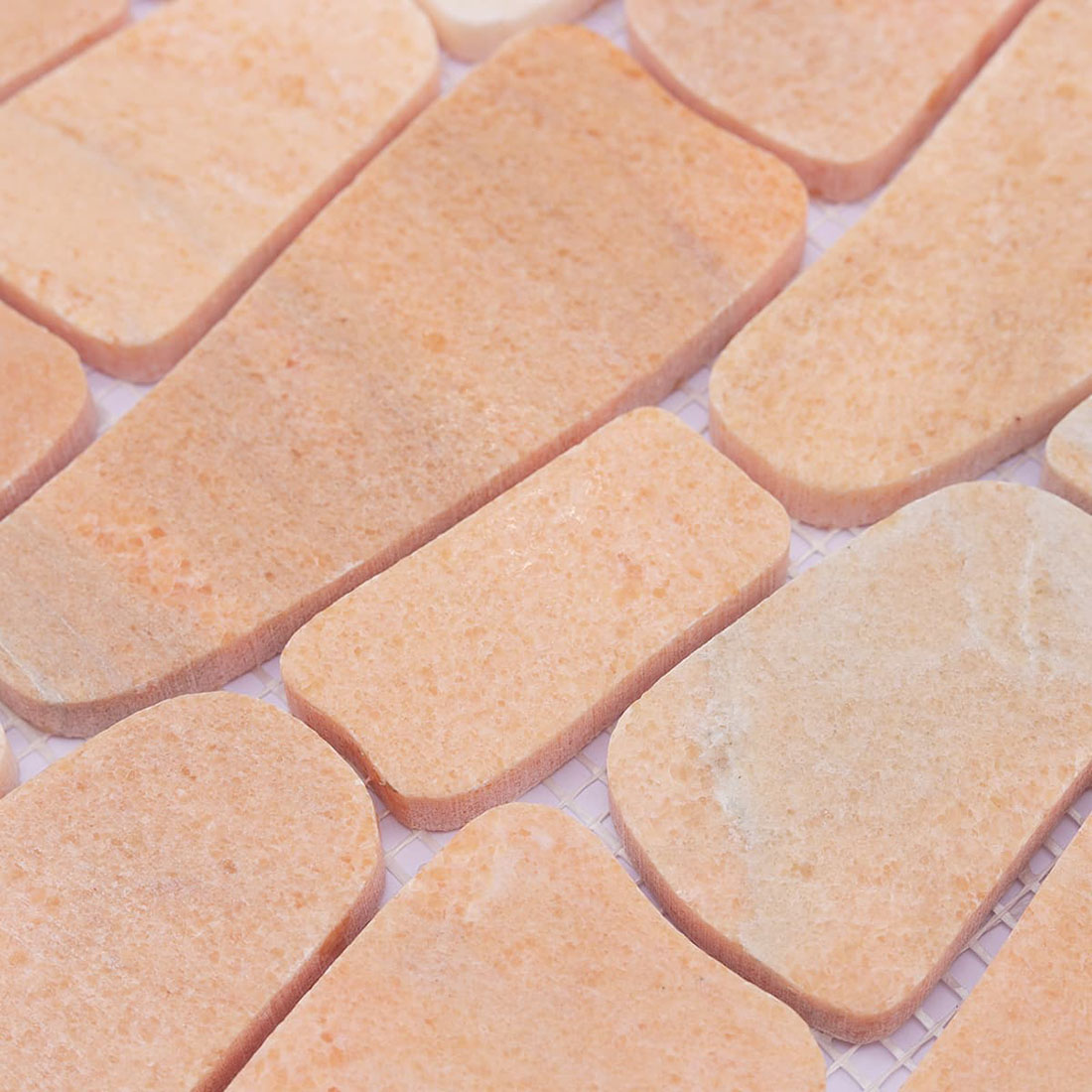 Mixed-shape peach stone mosaic tiles with smooth irregular edges