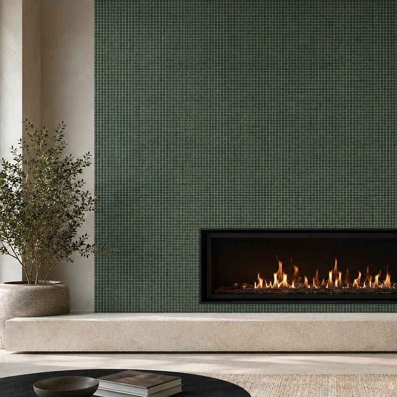 Close view of a modern fireplace framed by dark green square mosaic tiles
