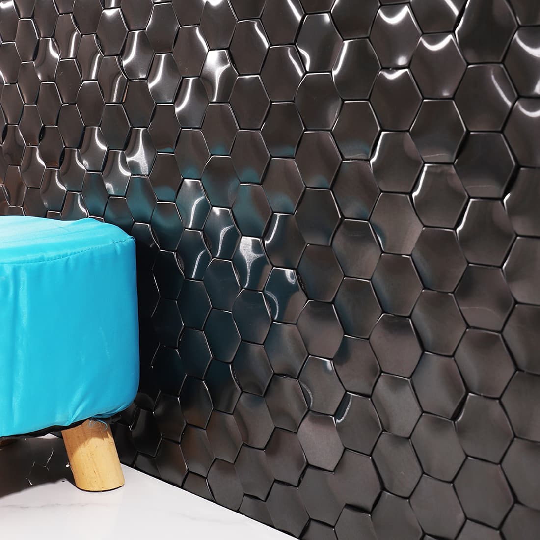 Modern interior scene featuring a black hexagon metal mosaic tile accent wall.