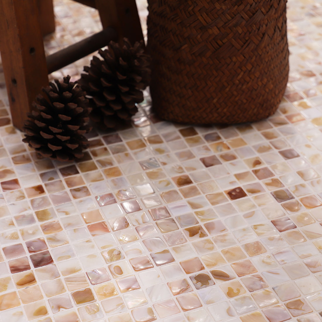 Closeup of mosaic floor next to woven basket and wooden stool