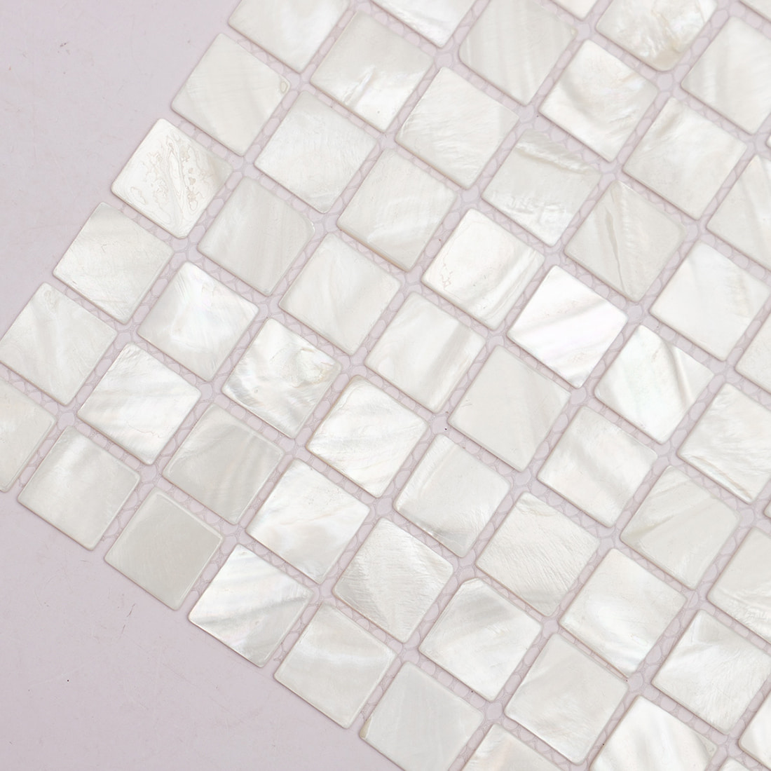 Diagonal corner closeup of glossy mother of pearl square mosaic tiles
