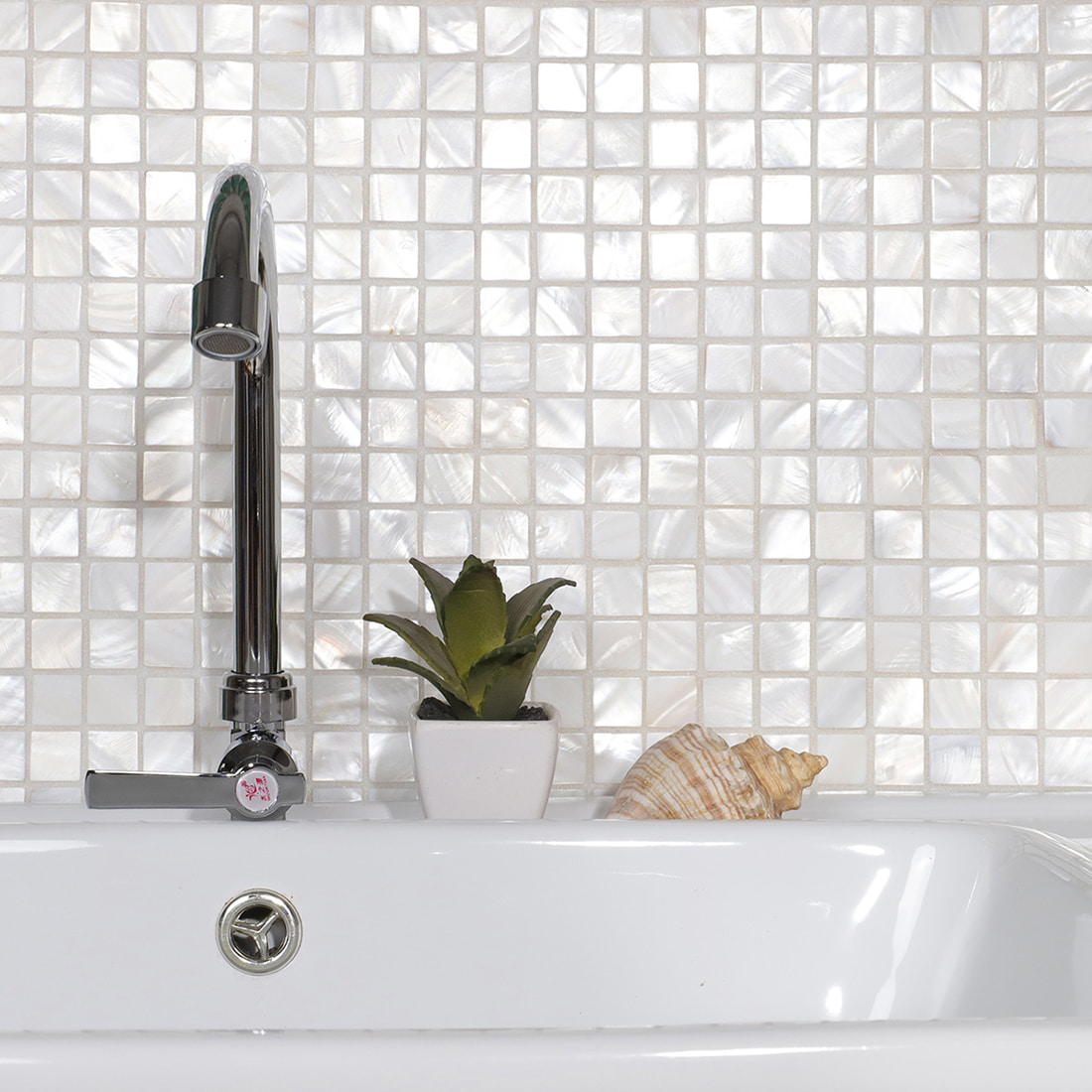Bathroom sink scene with mother of pearl square mosaic tile backsplash