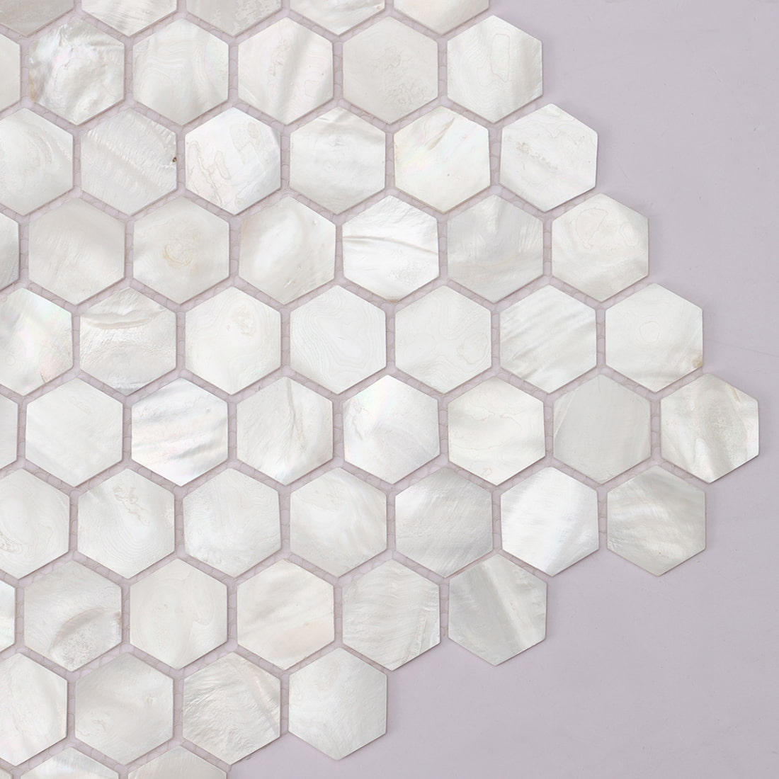 Corner close up of mother of pearl hexagon mosaic with grout gaps