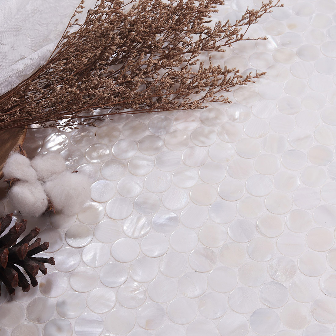 Lifestyle shot of mother of pearl penny round mosaic with dried flowers and pinecone