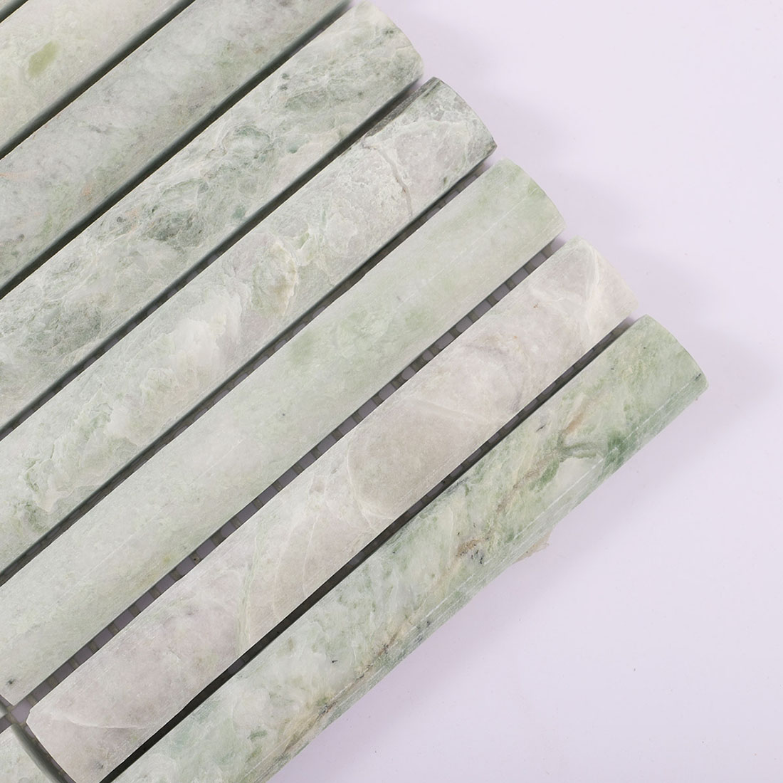 Detail of pale green marble half round strips with cloudy natural veining