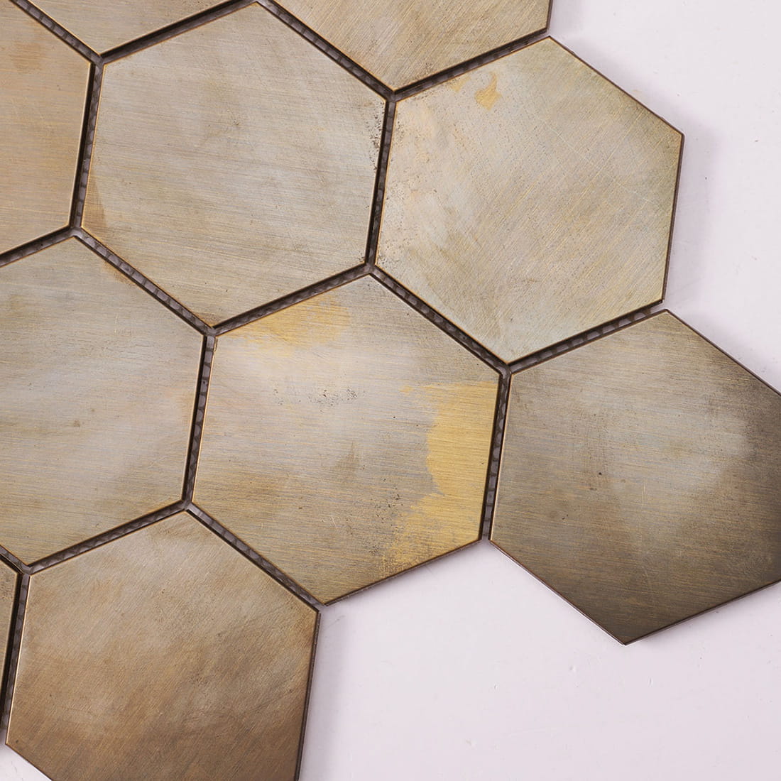 The patina finish and worn surface of antique brass hexagon mosaic tiles.