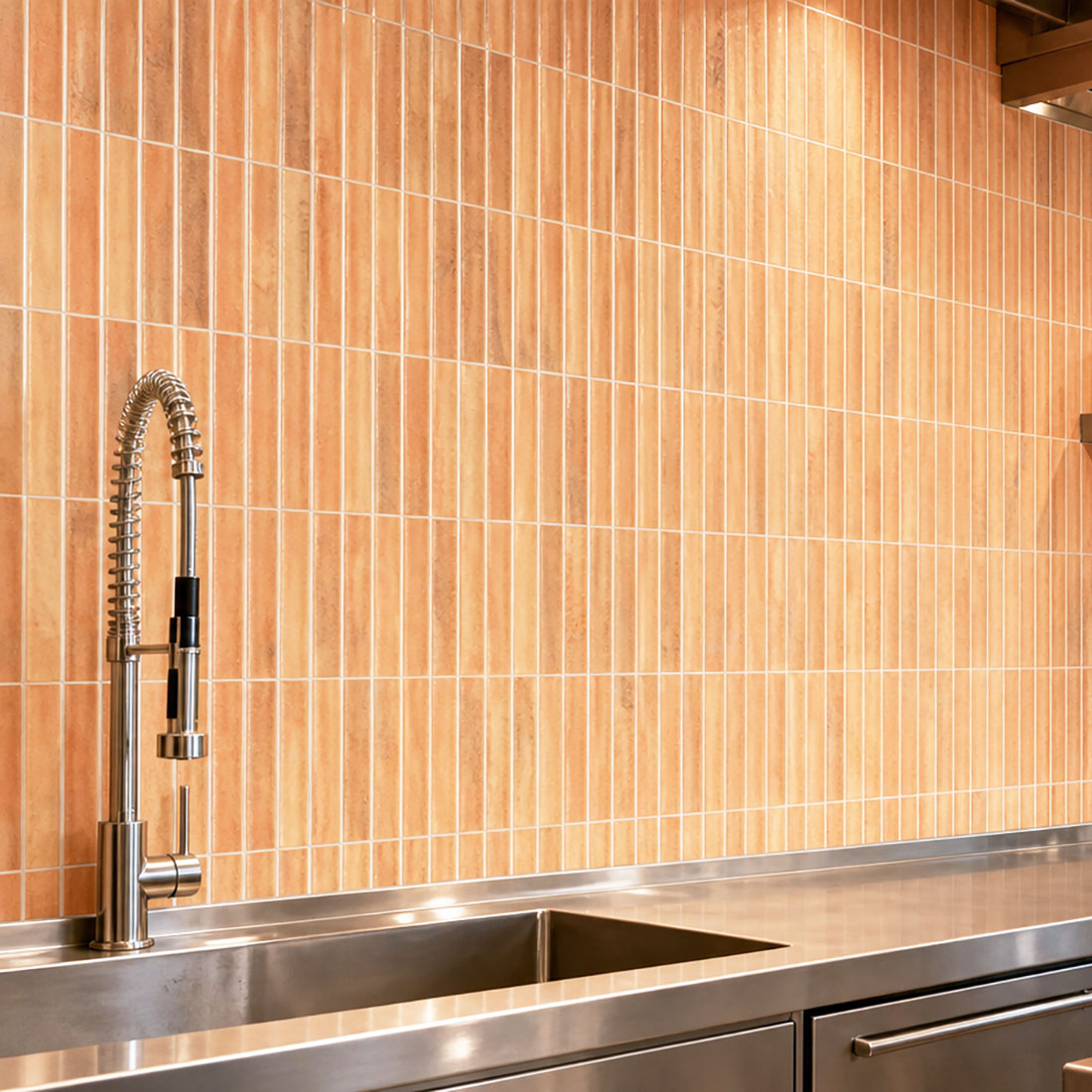 Peach grooved stone mosaic tiles installed vertically on a kitchen backsplash