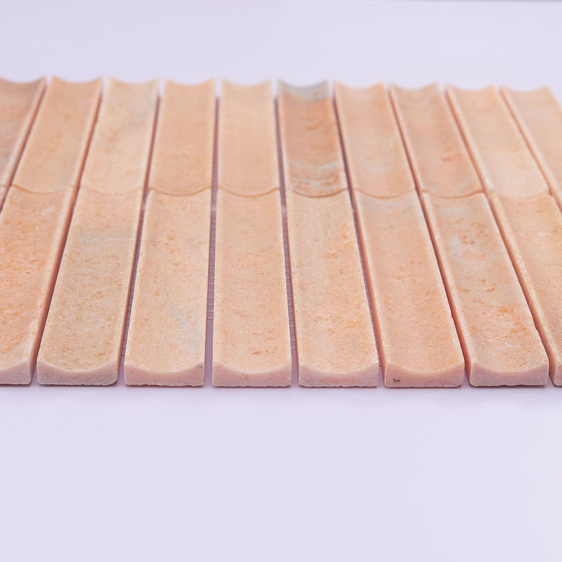 Front profile of peach grooved stone mosaic strips with curved surface channels