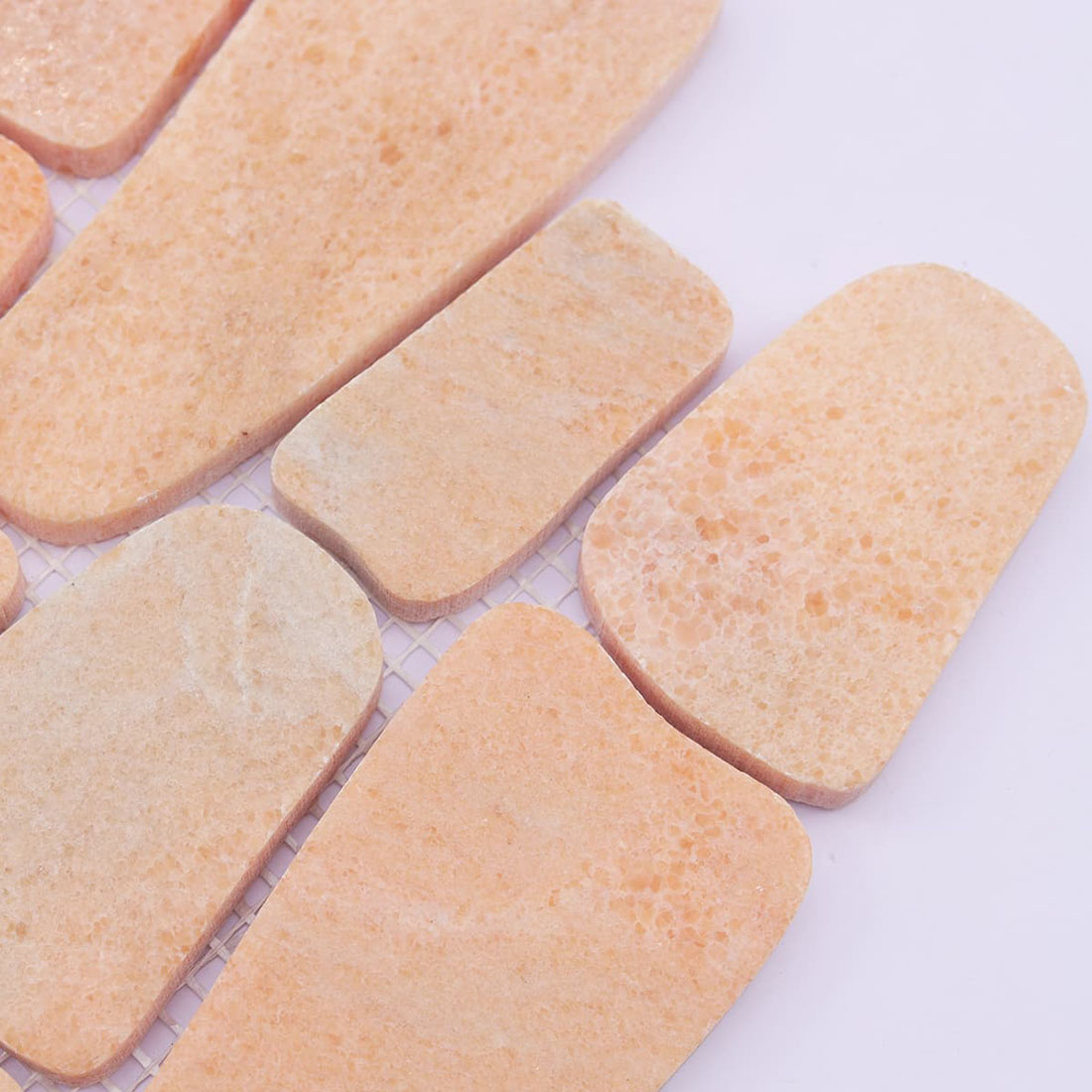Close-up of peach stone mosaic tiles showing natural texture and color variation