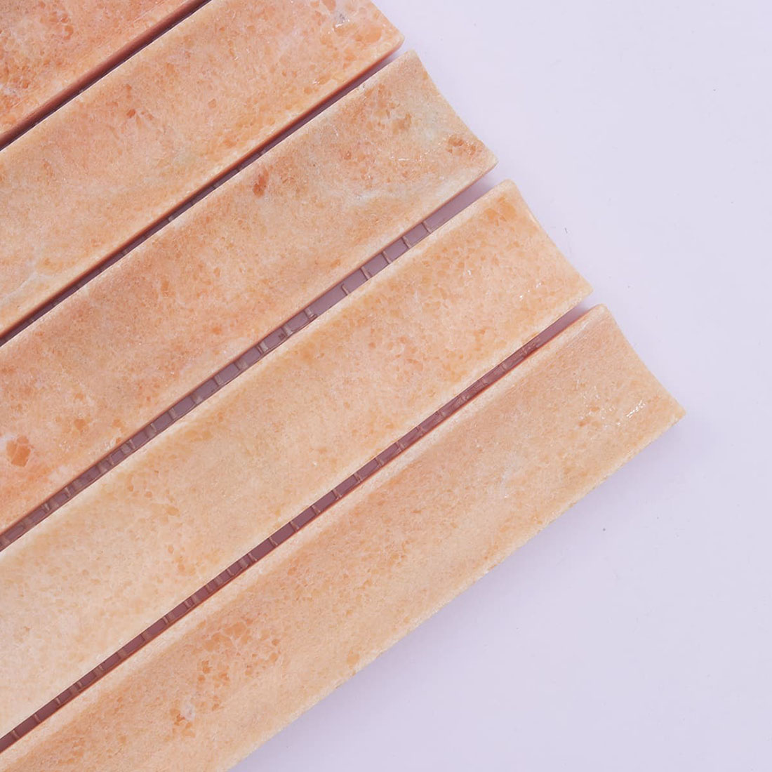 Close-up of peach stone mosaic strips with natural texture and color variation