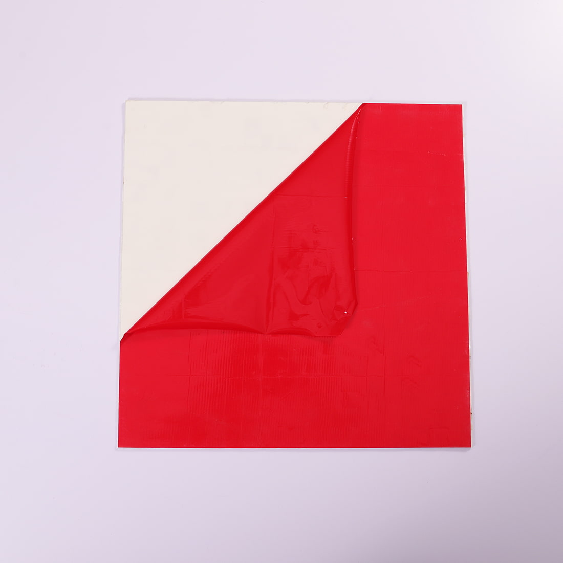 Peel-and-stick backing with red release film partially removed