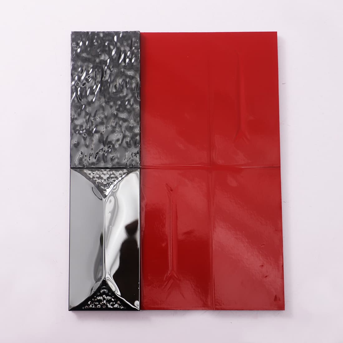 Back of black stainless steel tile showing red self adhesive layer.