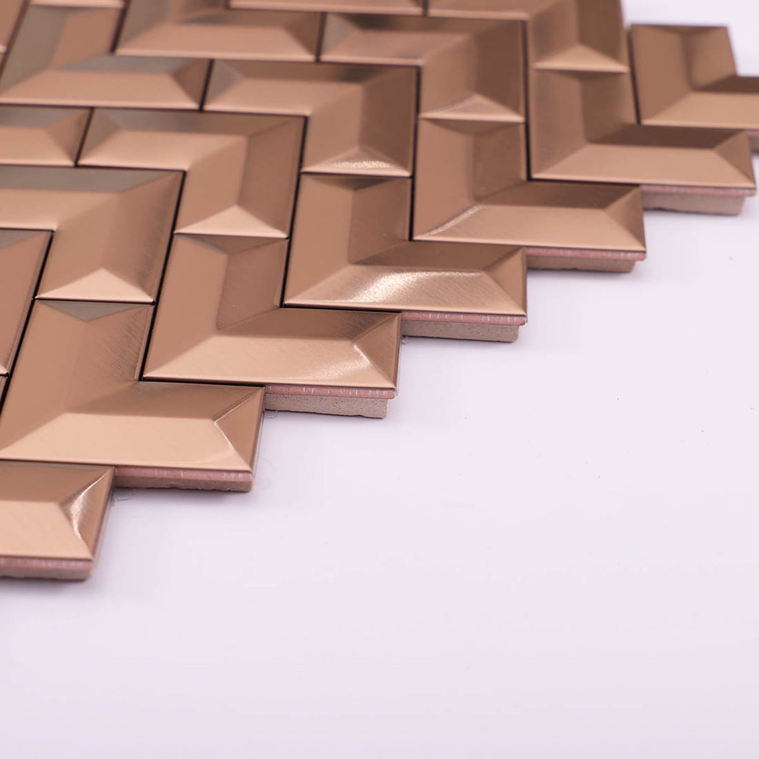 Angled perspective view showing the 3D beveled rose gold chevron metal tiles.