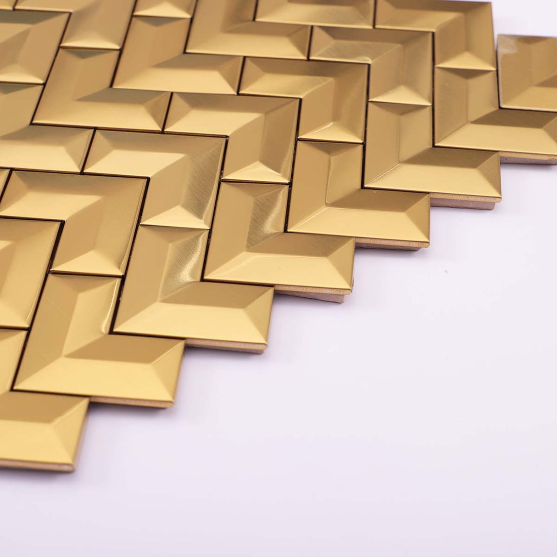 Angled perspective view of 3D brushed gold chevron stainless steel wall tiles.