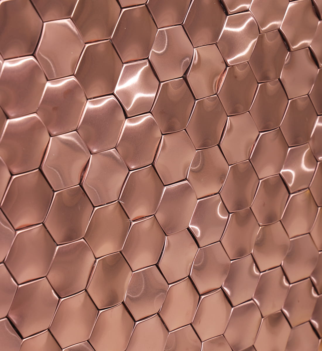 Wide perspective view of an installed rose gold 3D hexagon metal mosaic wall.
