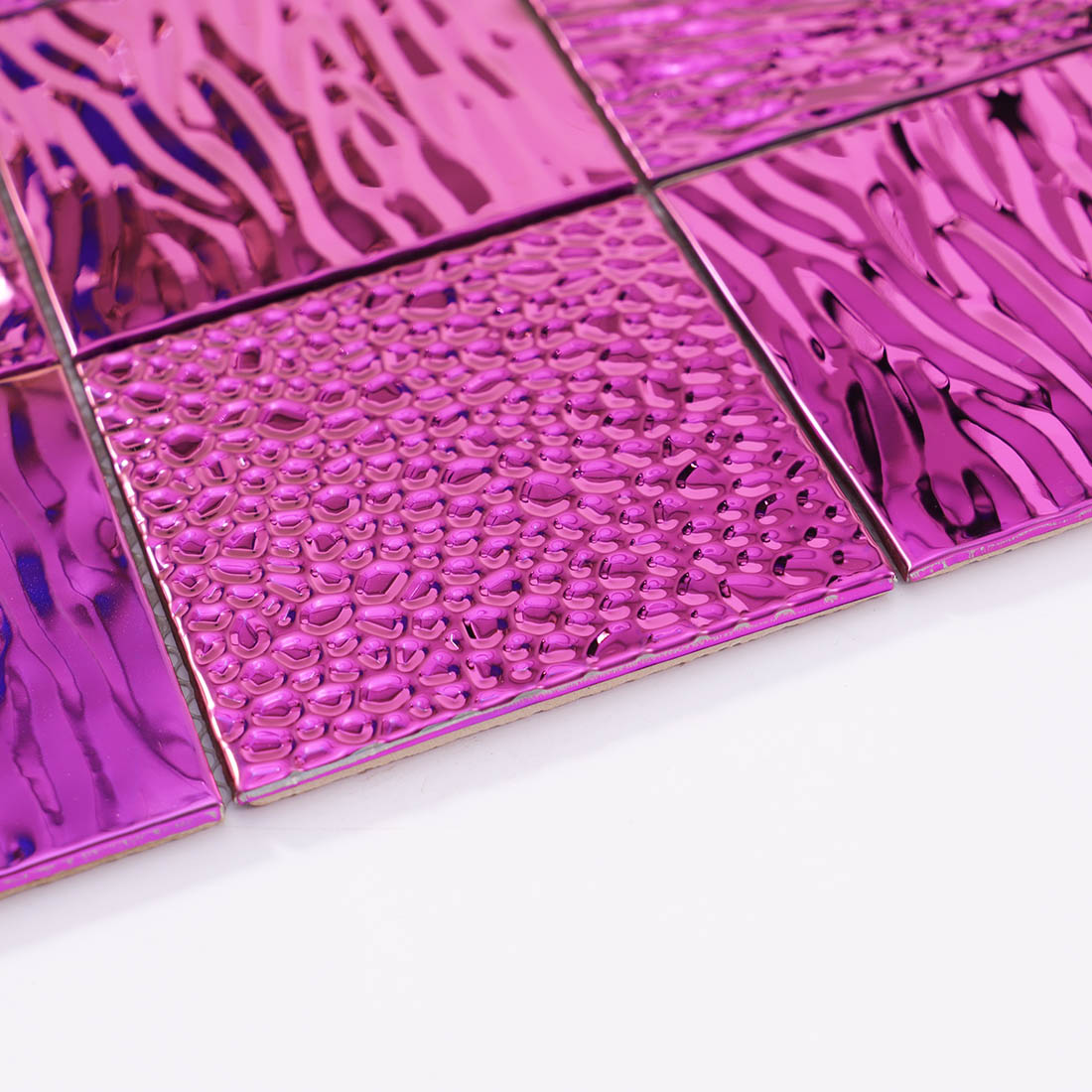 Close-up of pink raised texture and wavy stainless steel mosaic tiles