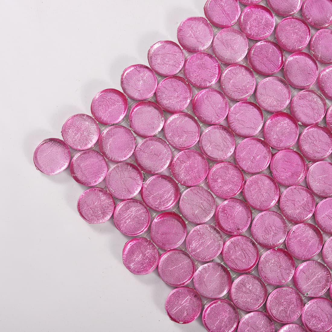 Close-up of pink round glass mosaic tile corner showing glossy texture