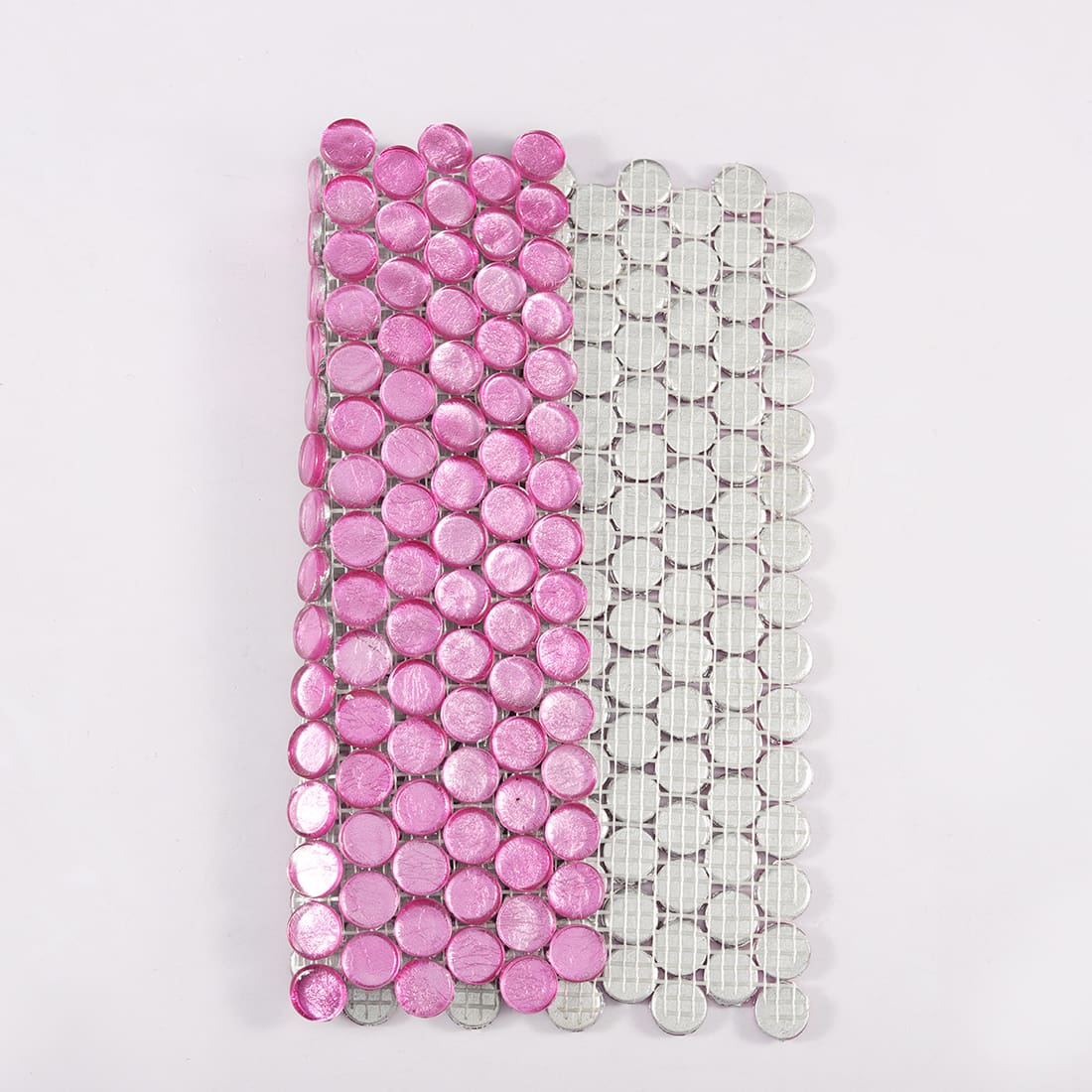 Pink round glass mosaic tile showing front surface and mesh backing