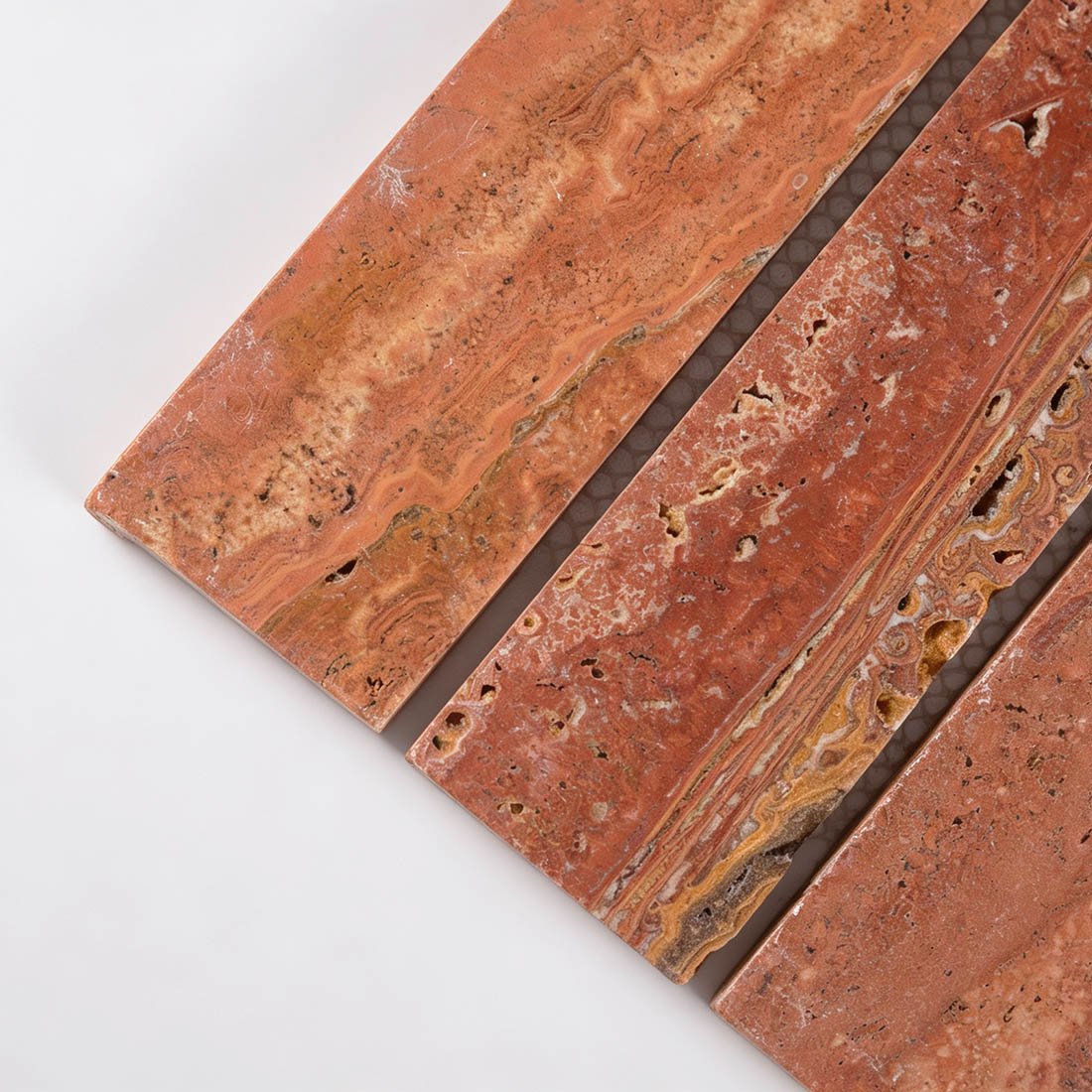 Close-up of red travertine wide bar mosaic tile with natural veining