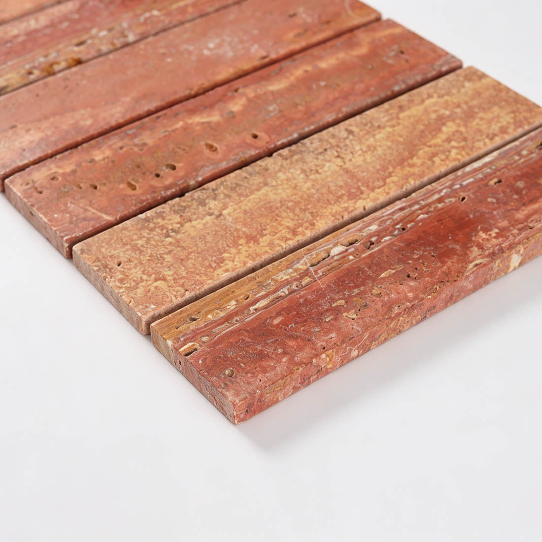 Close-up showing red travertine wide bar mosaic tile thickness and edges