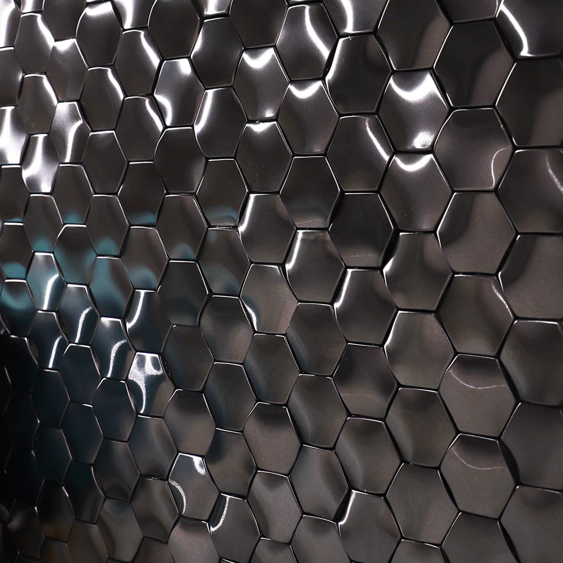 Extreme angled view of reflective black hexagon metal tiles on a wall.