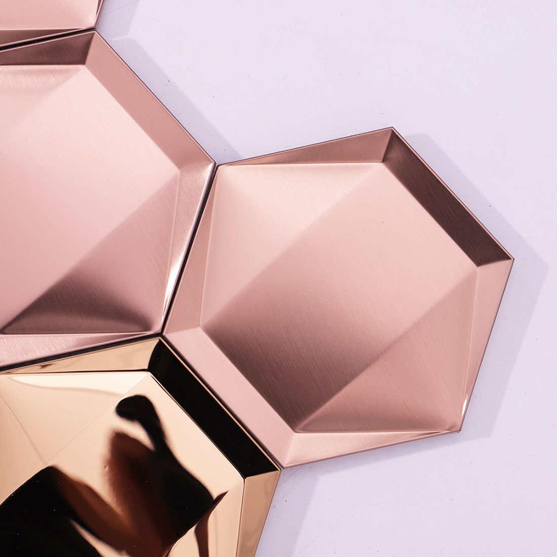 Close-up of brushed rose gold 3D hexagon stainless steel mosaic tiles