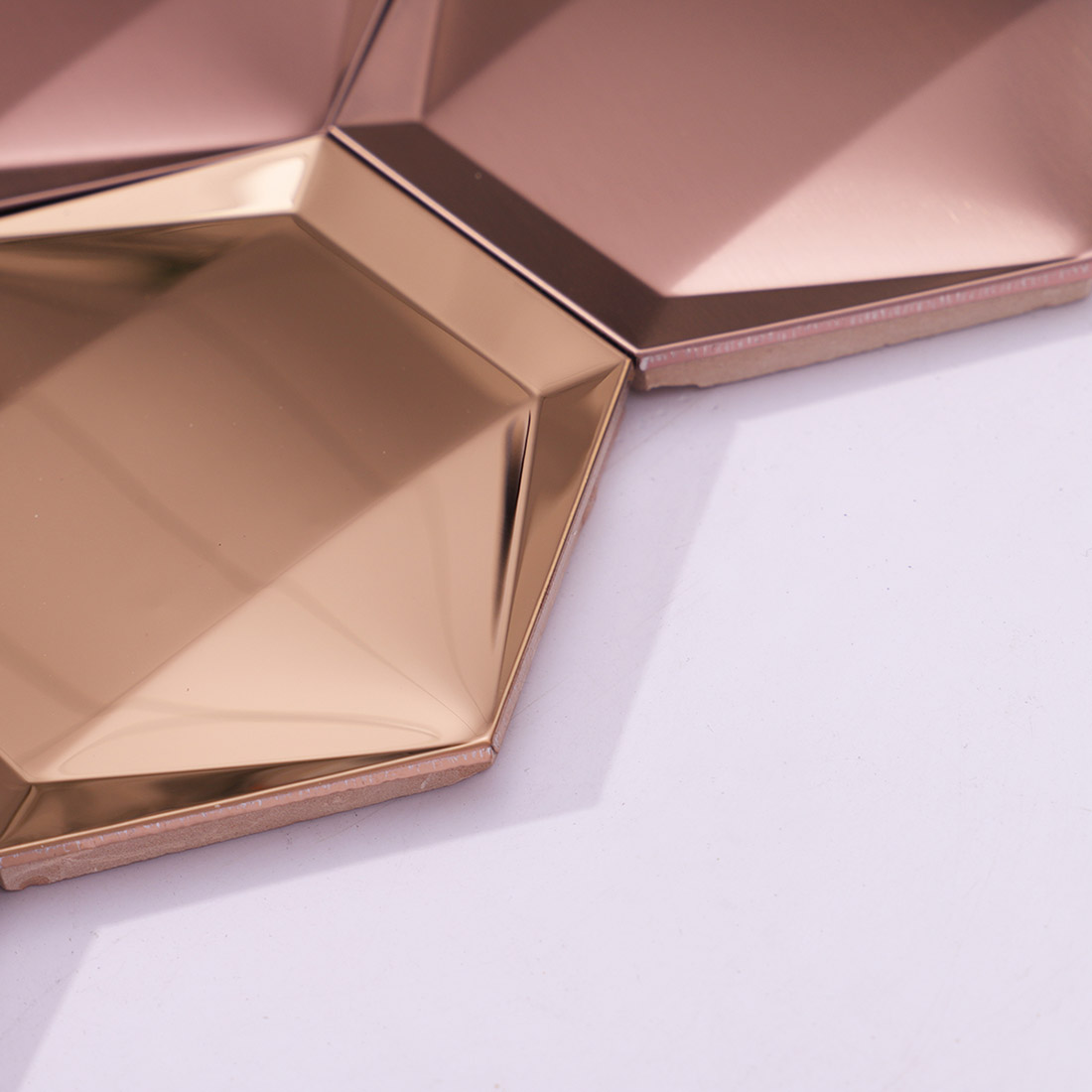 Edge detail of rose gold 3D hexagon stainless steel mosaic tiles