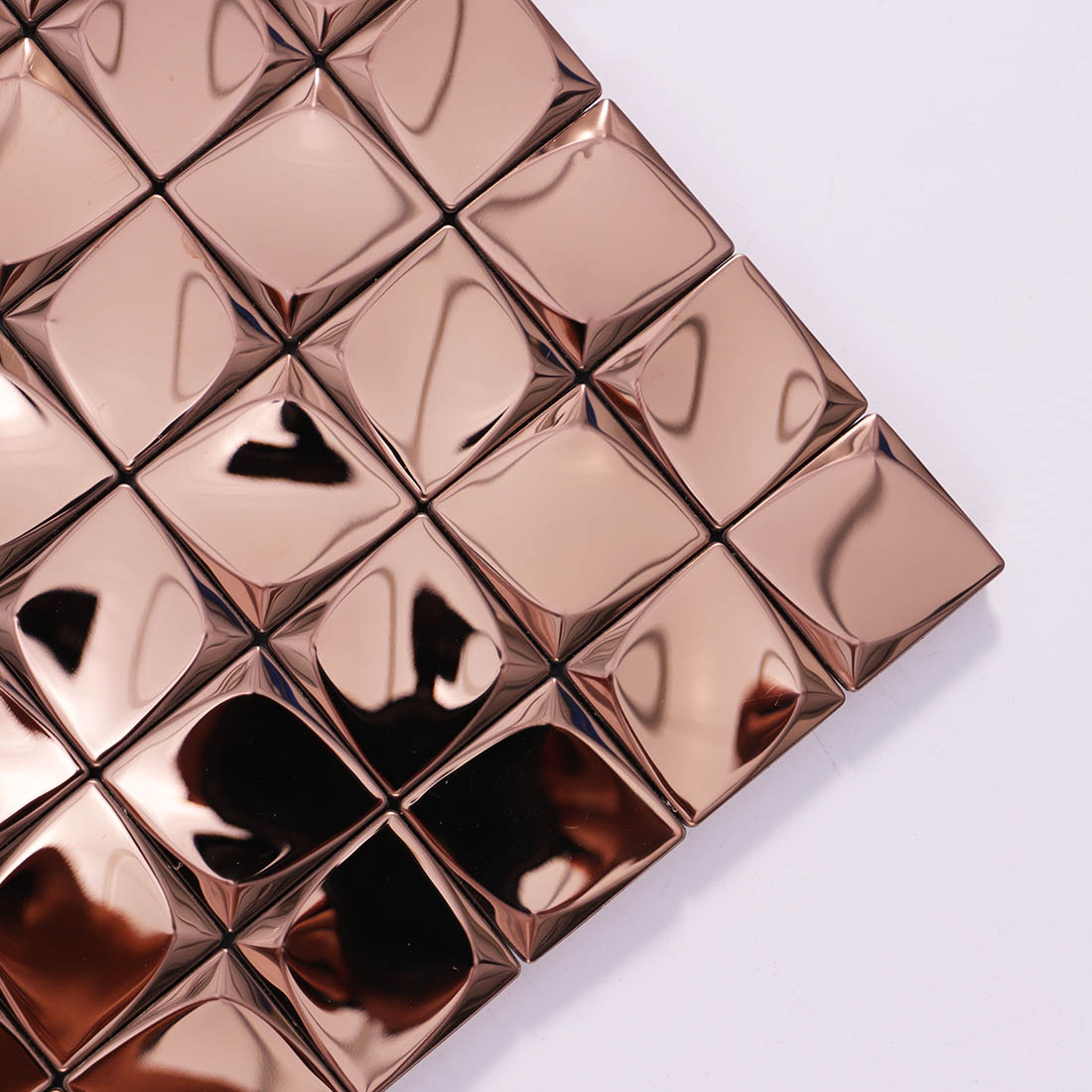 Corner detail of rose gold 3D square metal mosaic tiles