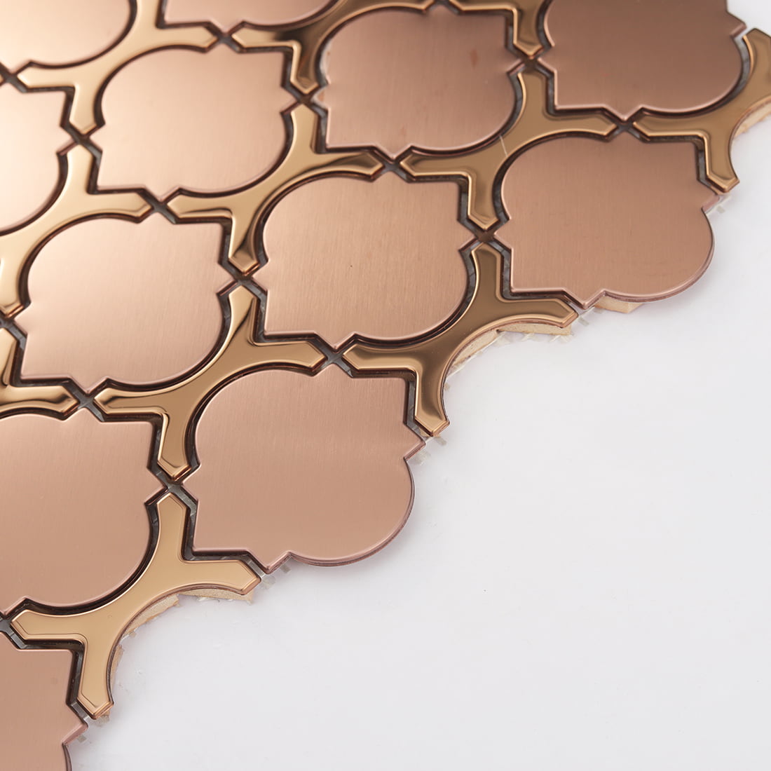 Angled detail of rose gold metal lantern mosaic showing layered thickness