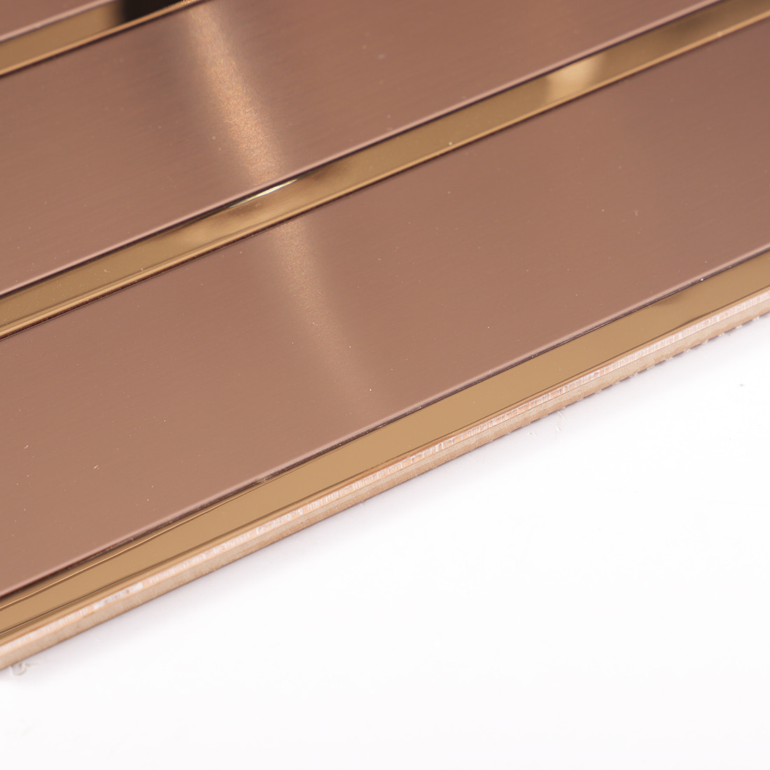 Close-up of rose gold metal mosaic tile backing and edge structure