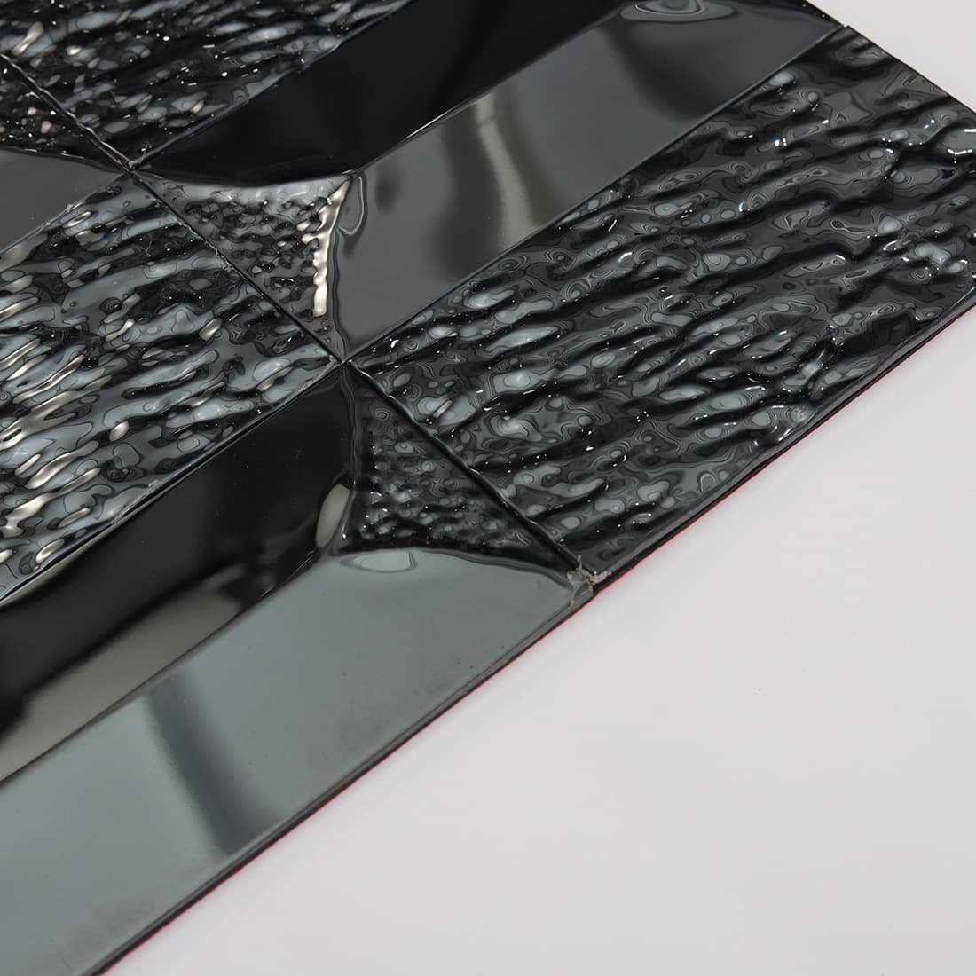 Side view showing the depth of black stainless steel mosaic tiles