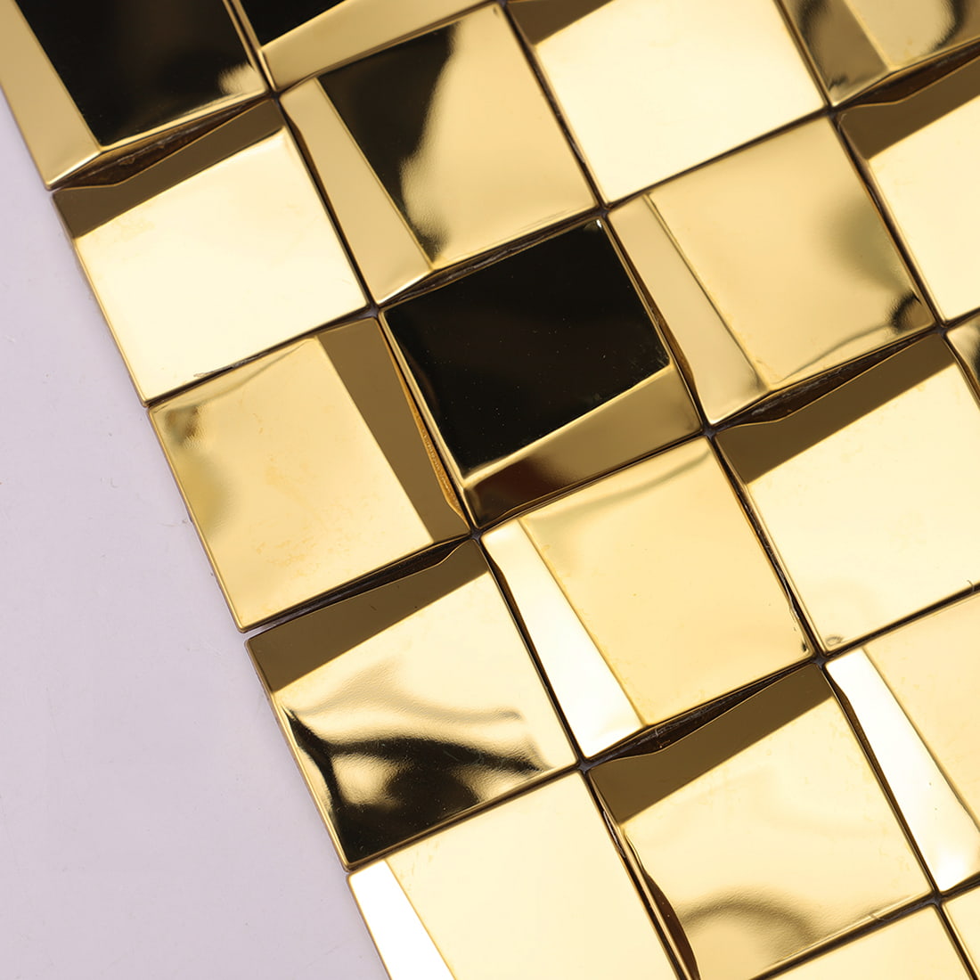 Detailed side texture and reflection of gold 3D square stainless steel tiles.
