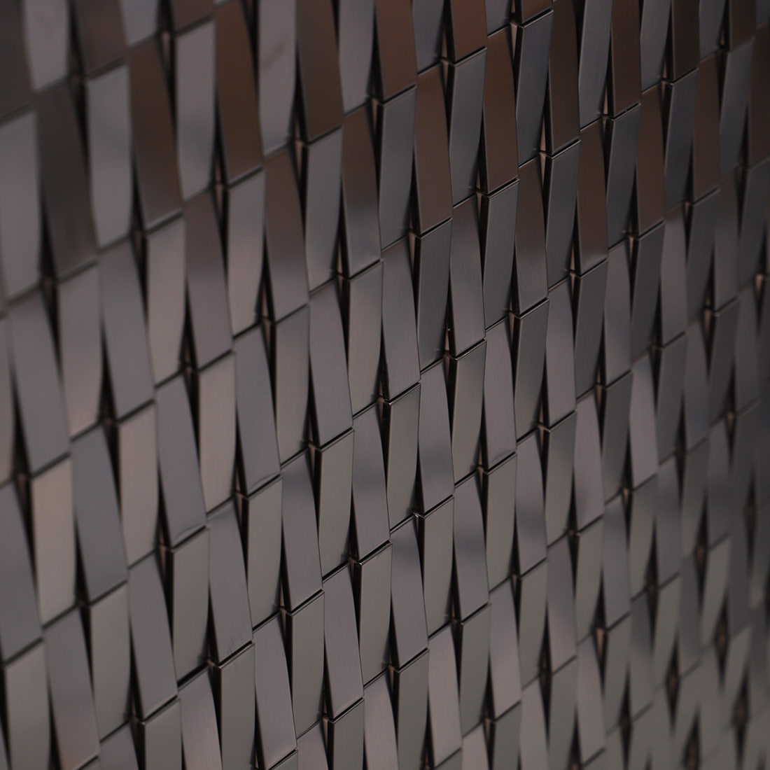 Side view showing the slanted 3D effect of black rectangular stainless steel tiles.