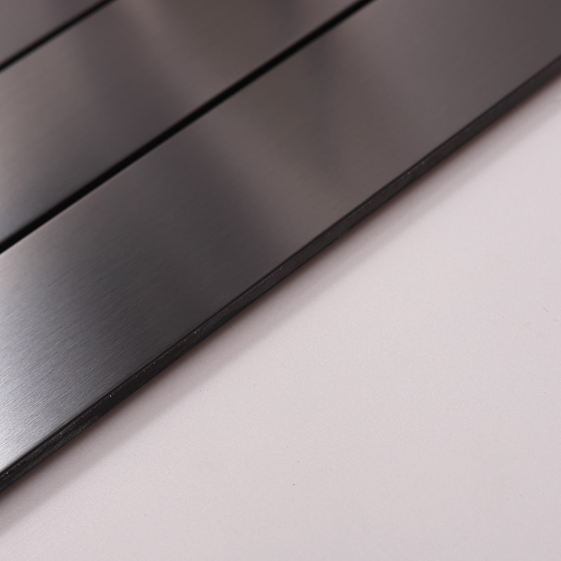 Side view showing the edge and thickness of black stainless steel tile.