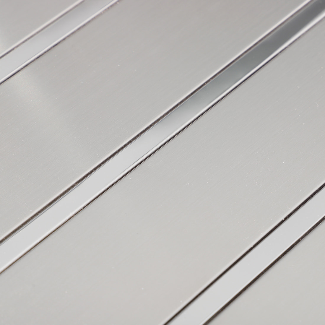 Surface detail of silver brushed metal mosaic tile with polished strips