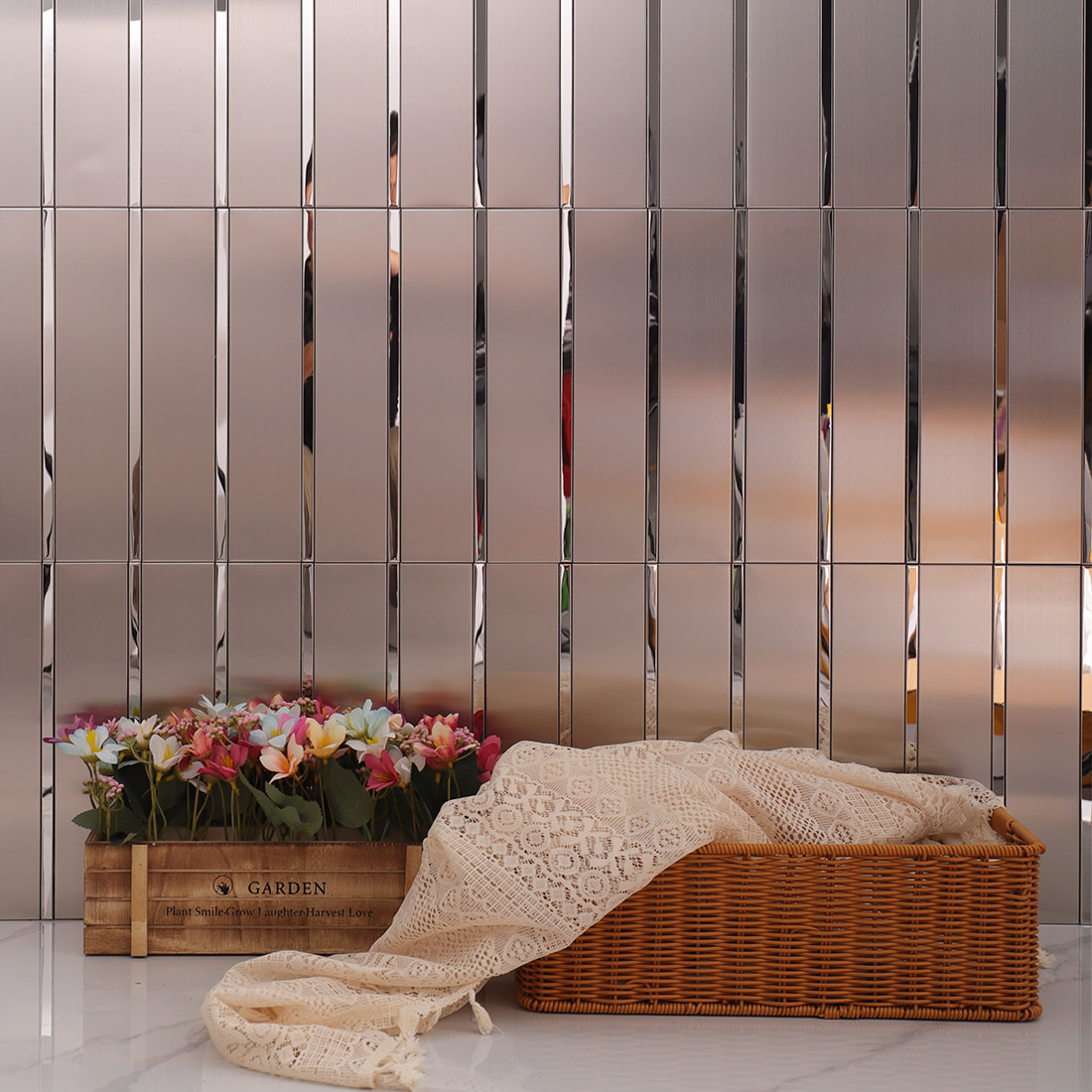 Silver brushed metal strip mosaic tile wall with decorative flowers and wicker basket