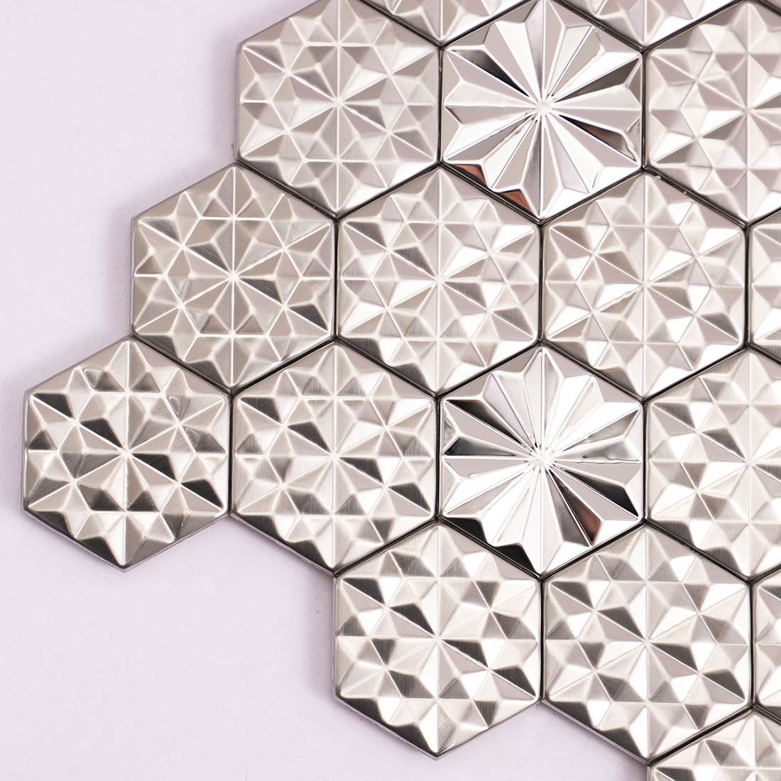 Corner detail of silver hexagon metal mosaic tiles with faceted patterns