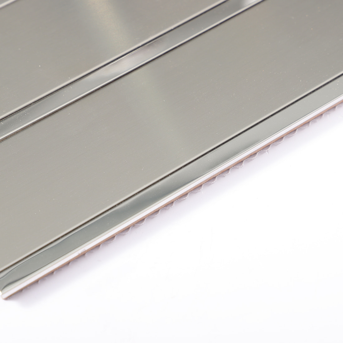 Close-up of silver metal mosaic tile backing and edge structure