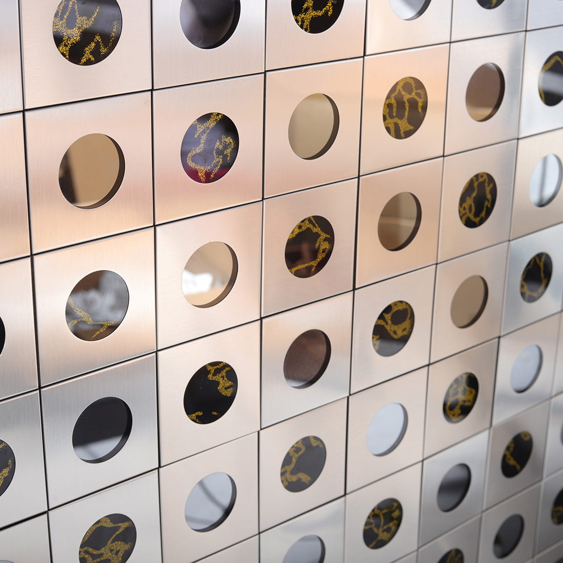 Full wall of silver brushed metal mosaic with round glass decor