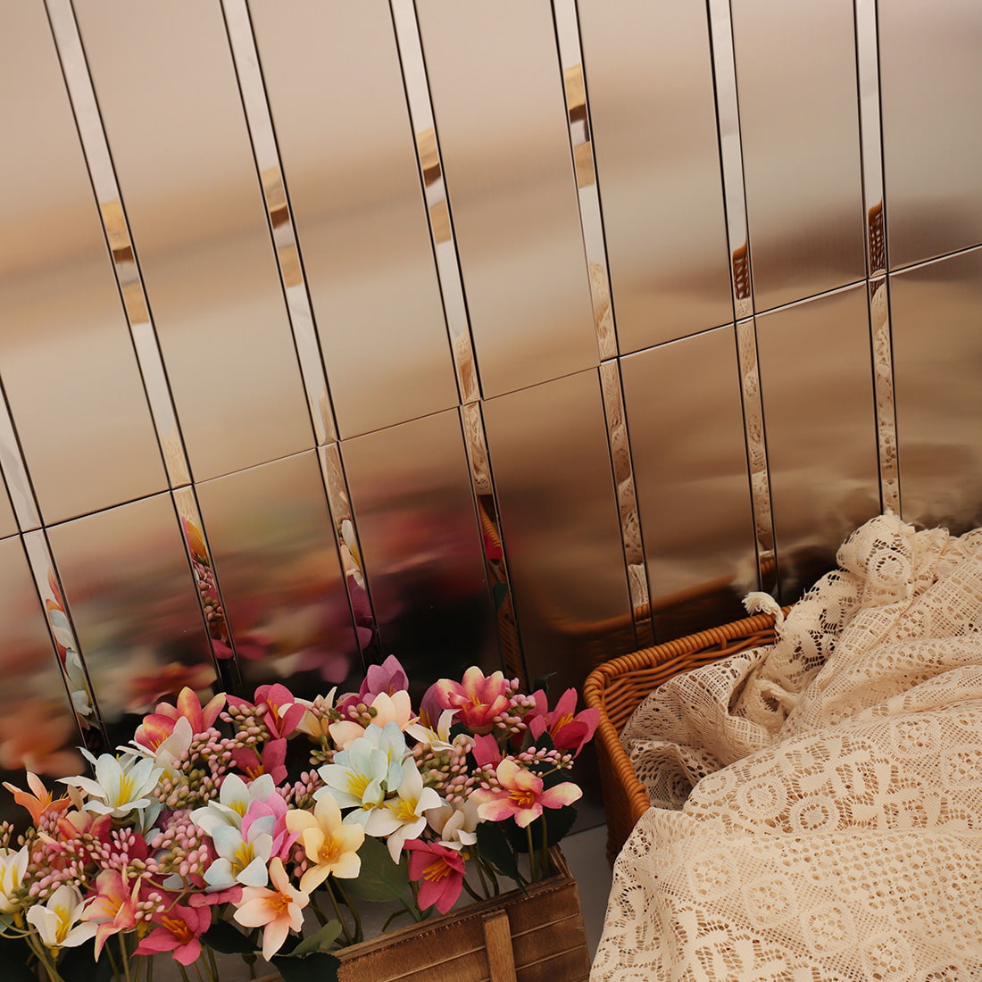 Close-up of silver metal mosaic tile wall with reflective surface and decorative props
