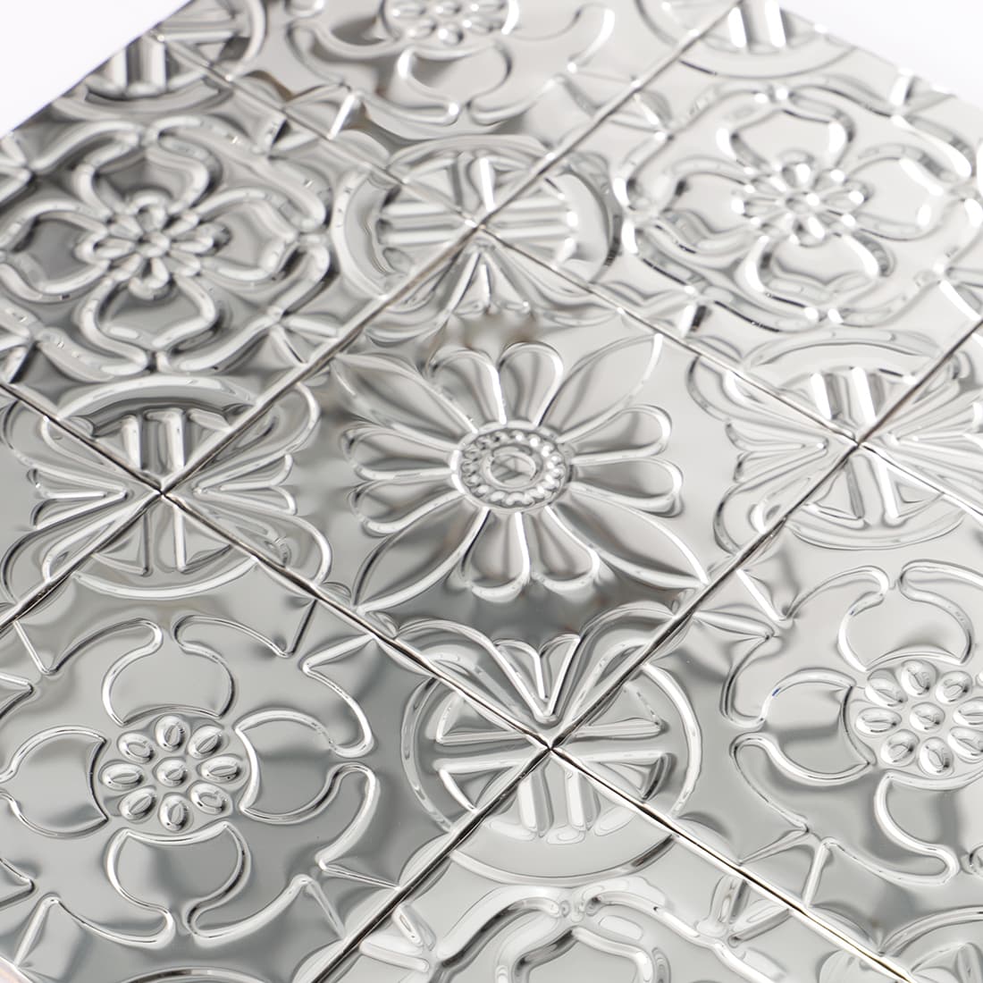 Macro shot of silver metallic embossed floral tile pattern texture