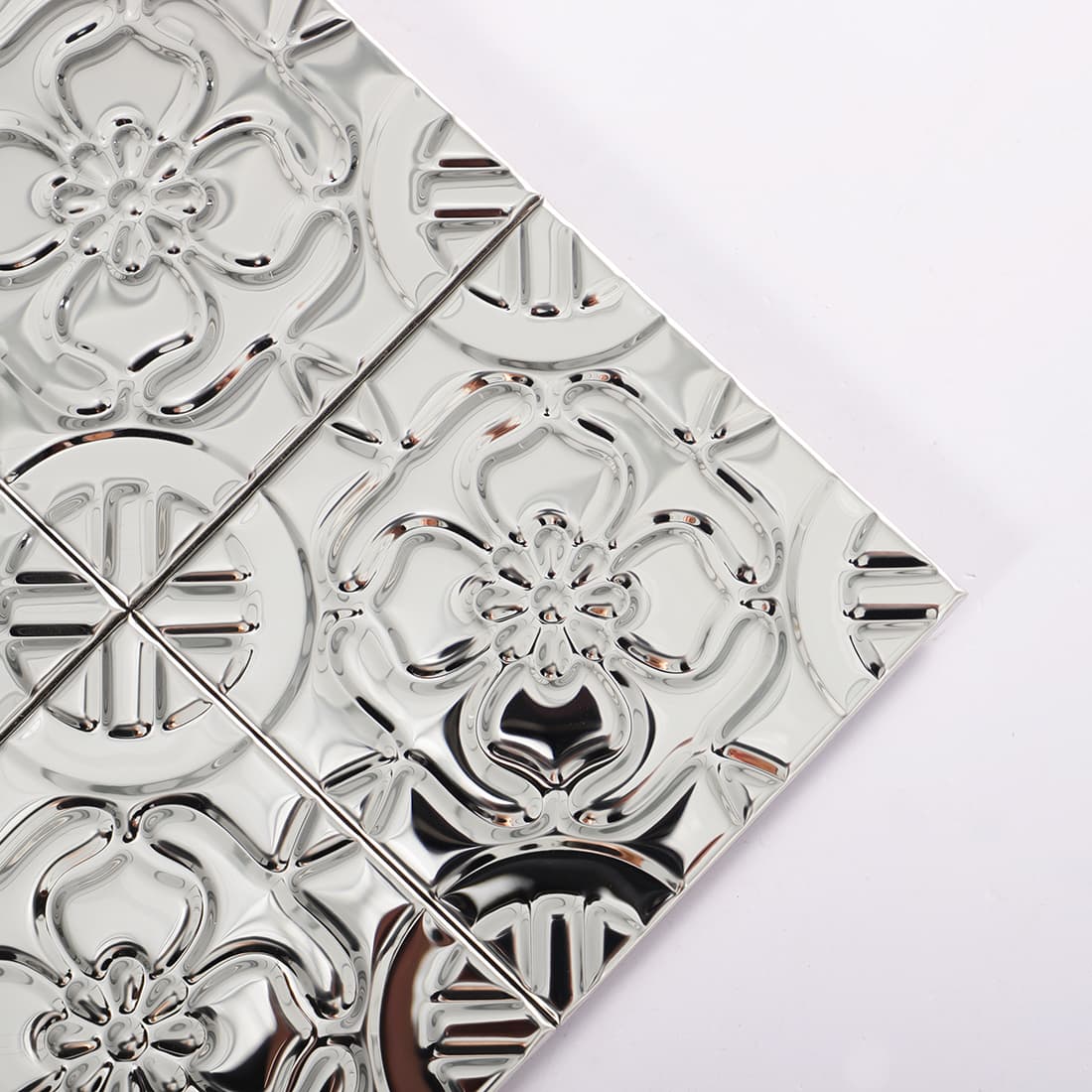 Close-up view of shiny silver floral mosaic tile corner