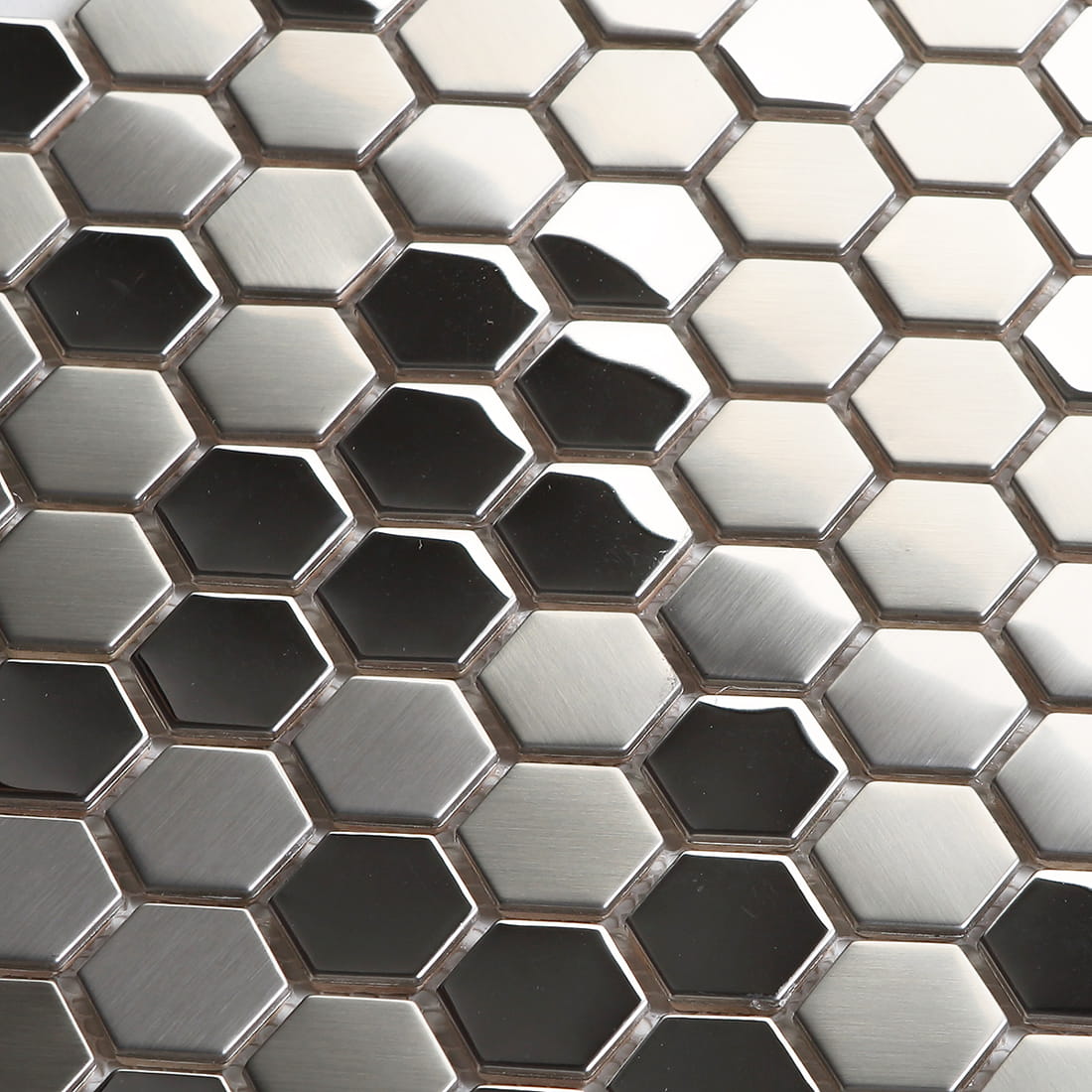 Detailed shot of silver brushed stainless steel hexagons with light reflections.