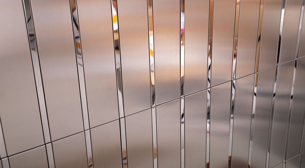 {"default":"Close-up of silver striped metal wall tiles with reflective trim"}
